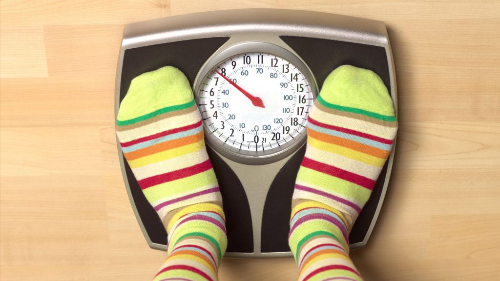 Dieting woman on bathroom scales